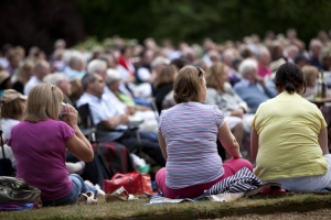 Audience at an outdoor theatre event at Shaw's Corner, Hertfordshire.